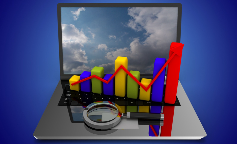 Sales growth chart displayed on a laptop screen with a magnifying glass.